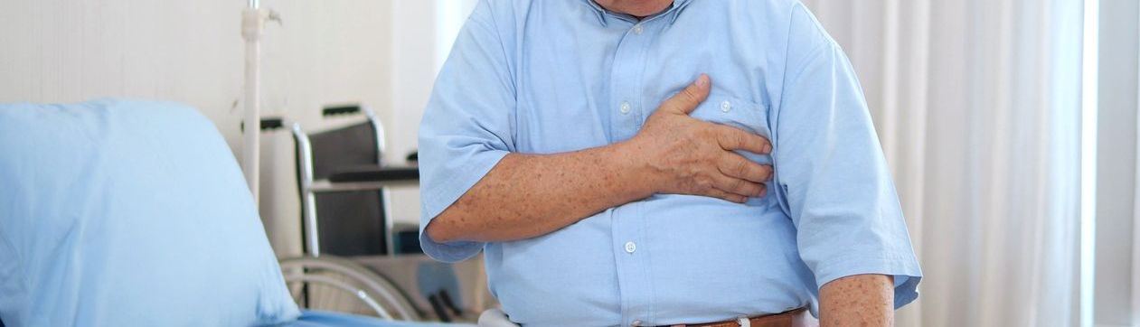 Man holding his chest demonstrating heart issues